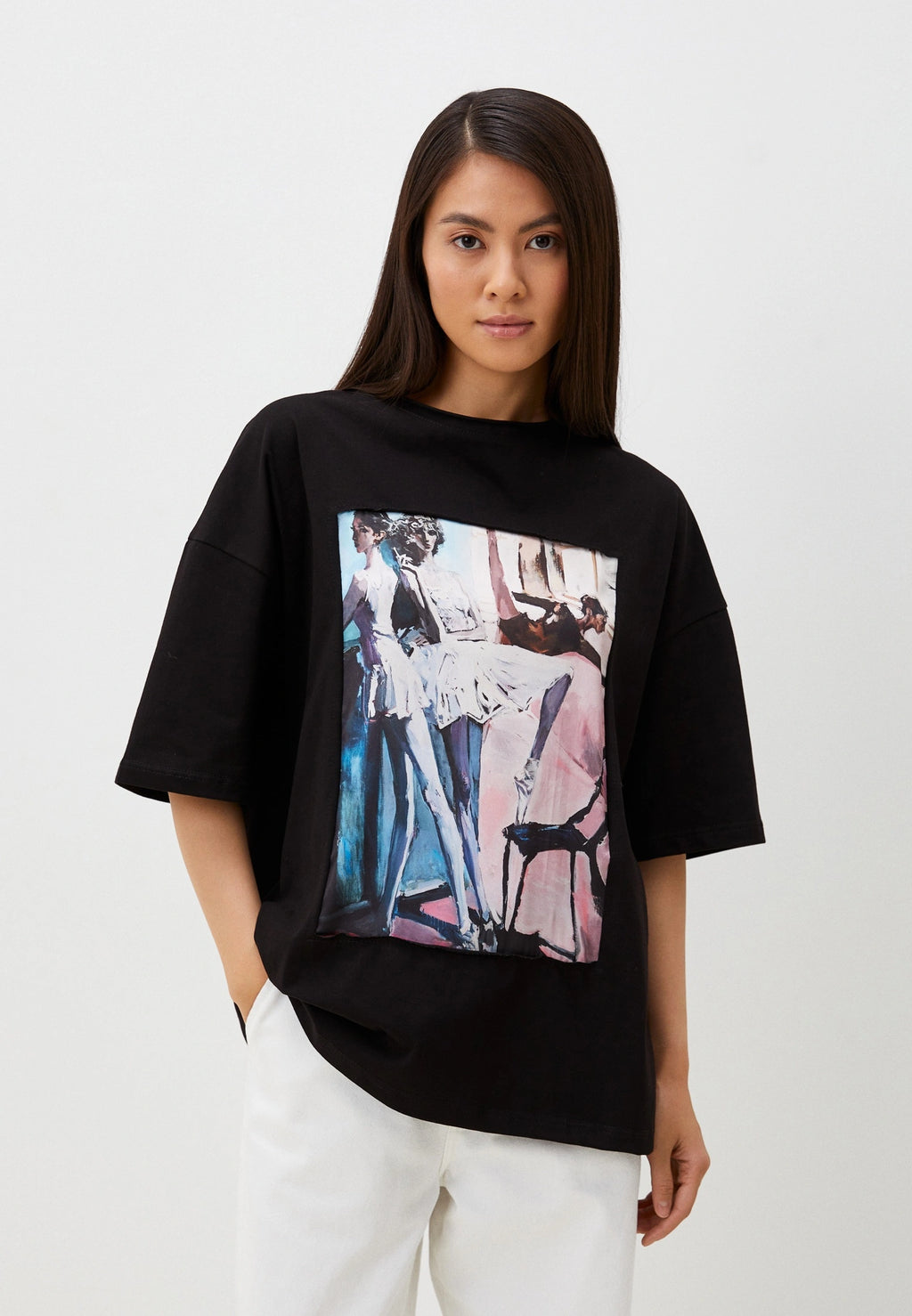 Person wearing a black t-shirt with a colorful graphic design on a white background