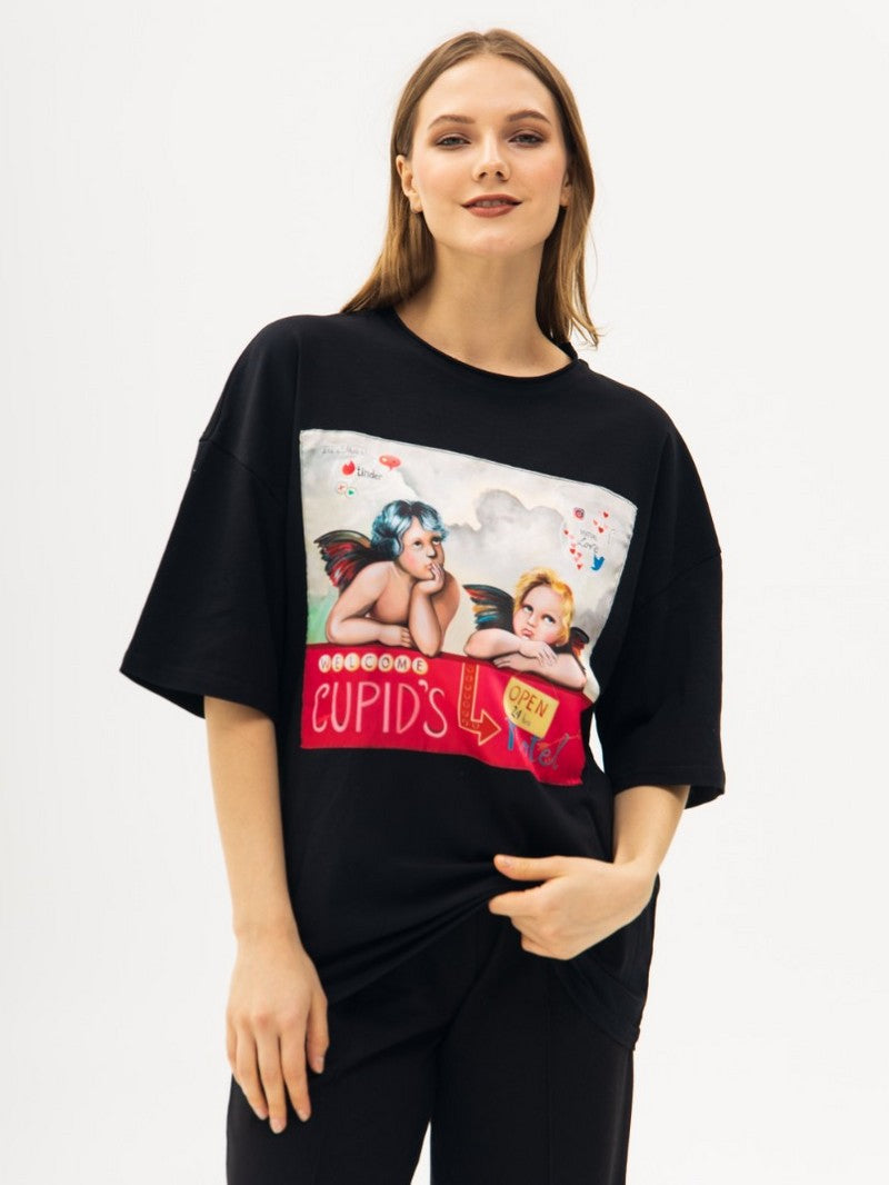 Person wearing a black t-shirt with a graphic design with cupids on a white background