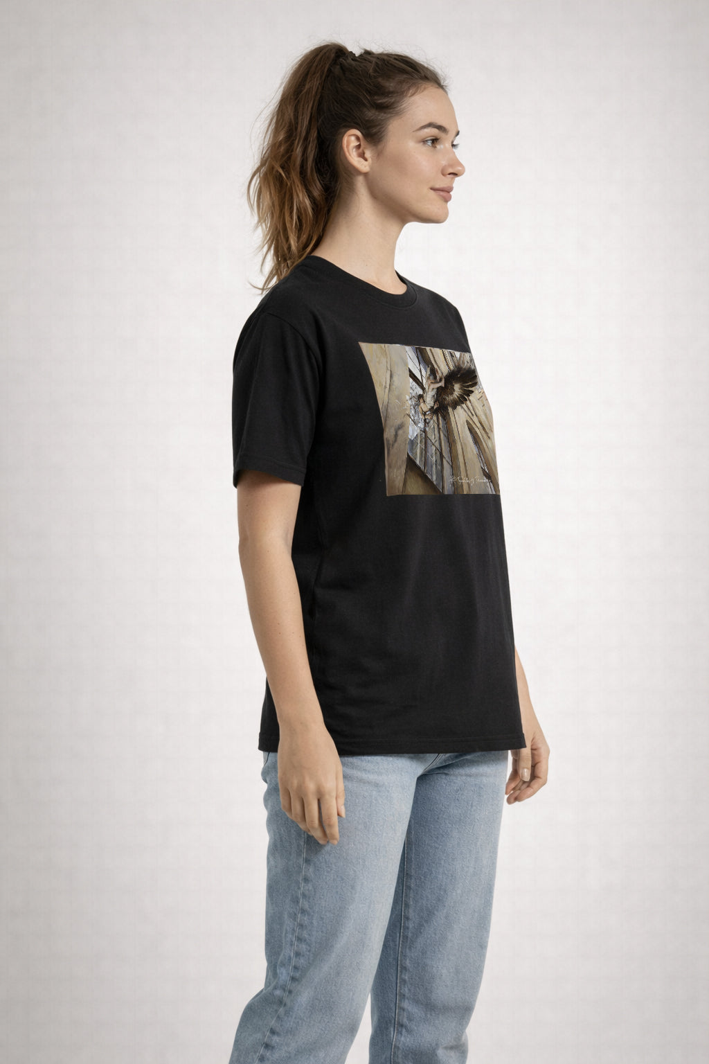 Person wearing a black t-shirt with a printed pictures on a plain background