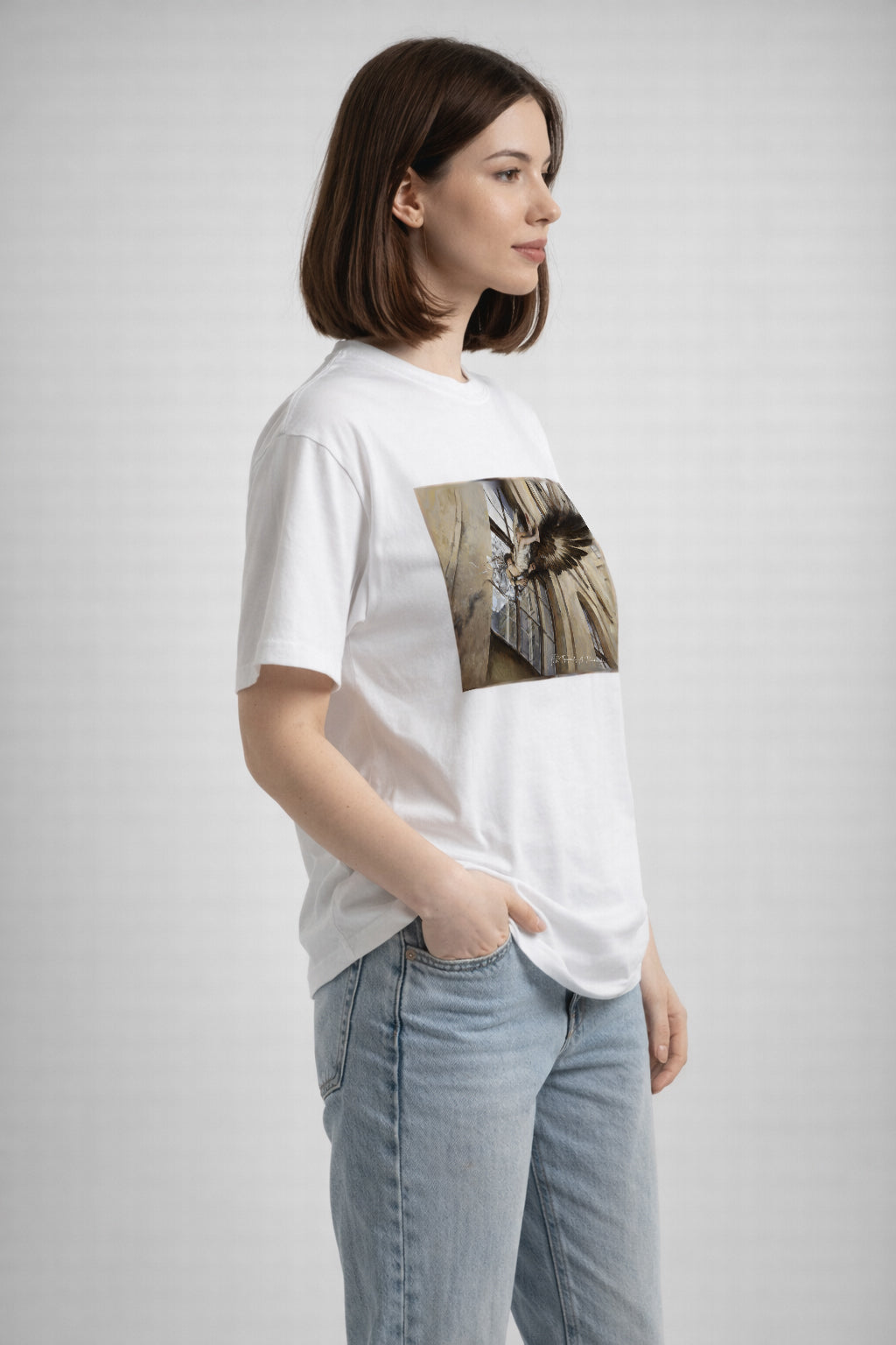 Woman wearing a white t-shirt with a graphic design on a plain background