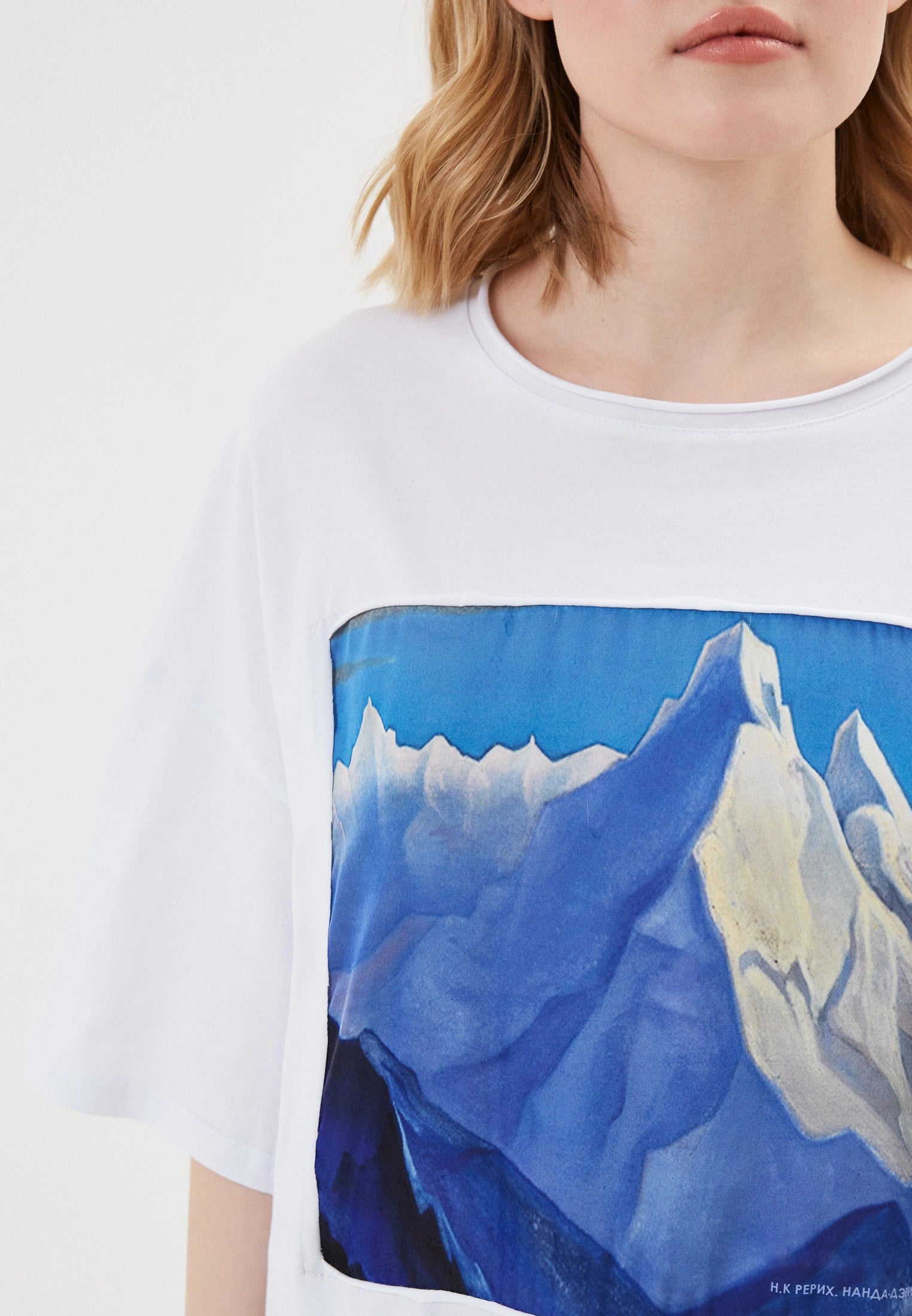 White t-shirt with a mountain graphic worn by a person