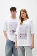 Two people wearing white t-shirts with printed designs on a plain background