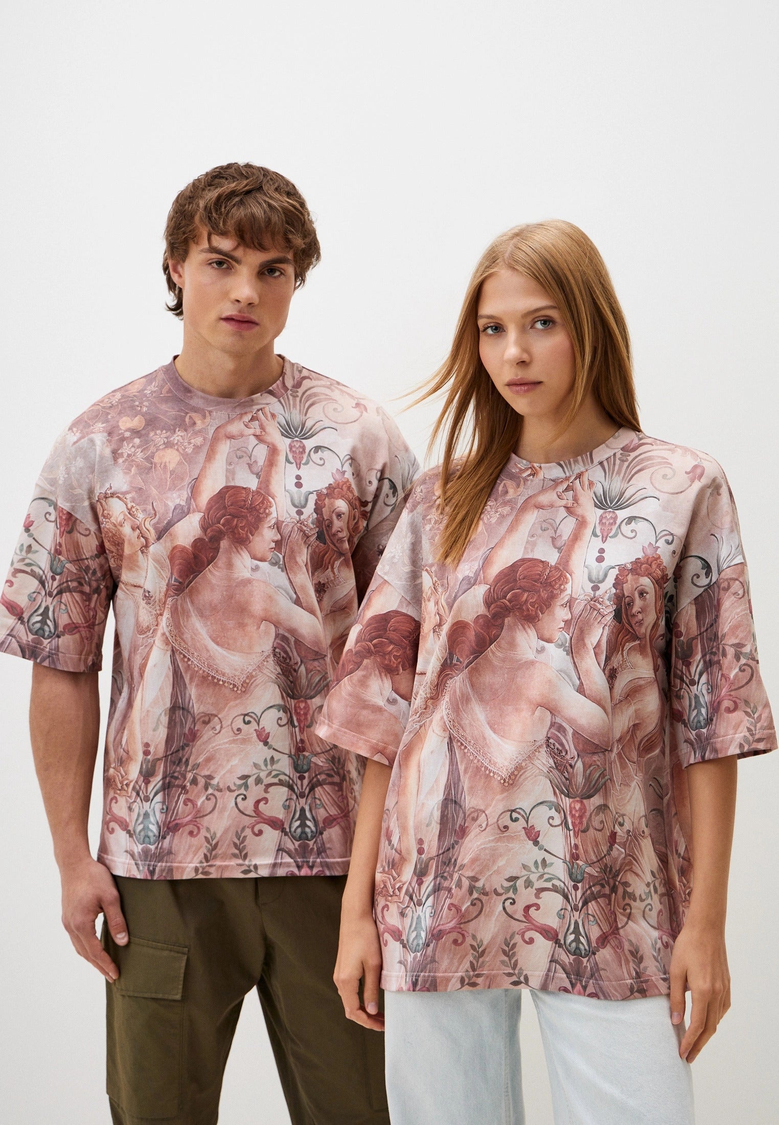 Two people wearing matching patterned shirts on a white background