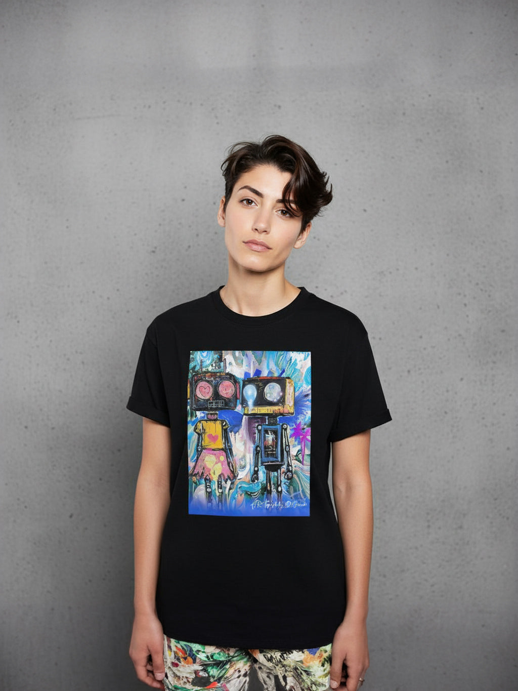 Person wearing a black t-shirt with a colorful robots graphic design on a gray background