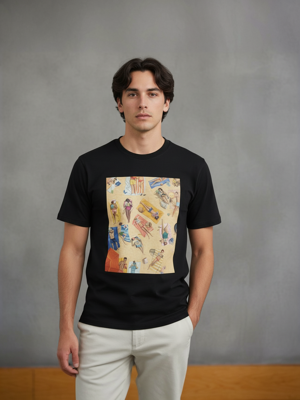 Man wearing a black t-shirt with a colorful graphic design on a gray background