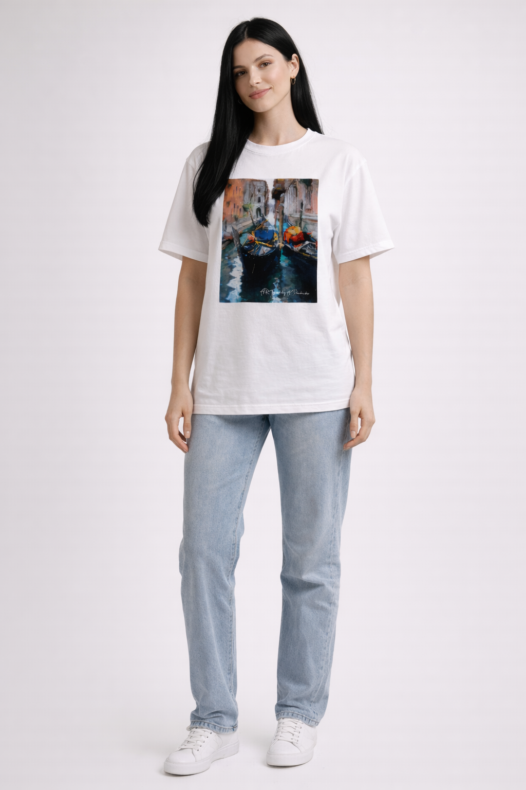 Woman wearing a white t-shirt with a graphic design of a canal scene, standing against a plain background.